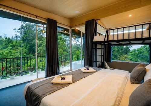 a bedroom with a large bed and large windows at Lavee Villa Ella in Ella