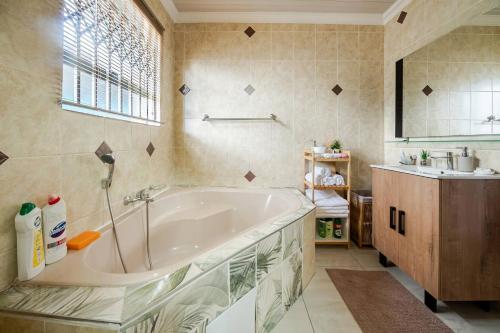 a bathroom with a large tub and a sink at Executive en-Suite, cozy, comfy and spacious in Baragwanath