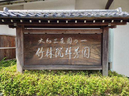 a sign with japanese writing on it in the grass at Chikurinin Gunpoen in Yoshino