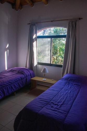 a bedroom with two beds and a window at Casa Armonía in Villa Las Rosas