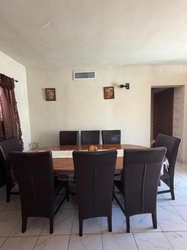 a dining room table with chairs and a large table at Casa Rivota in Delicias