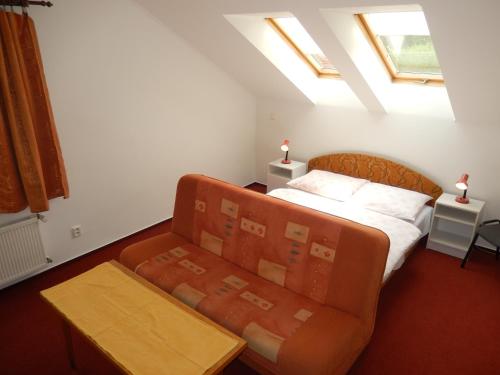 sypialnia z łóżkiem i kanapą w obiekcie Penzion v Infocentru w mieście Srbská Kamenice