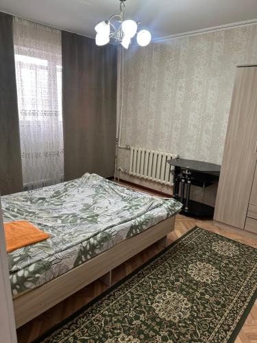 a bedroom with a bed and a piano at Грин сити in Balykchy