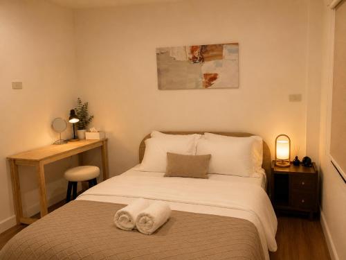 a bedroom with a bed with two towels on it at Punnawithi House Bangkok in Amphoe Phra Khanong