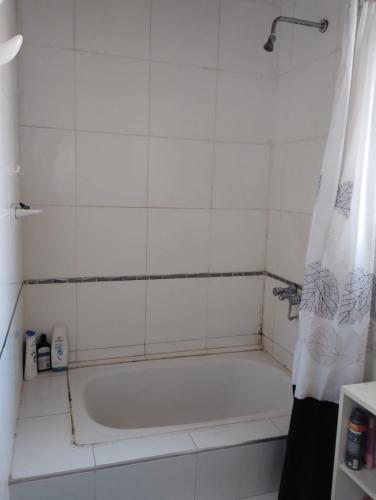 a bathroom with a white tub with a shower curtain at Casa quinta Los Teros in Sánchez de Loria