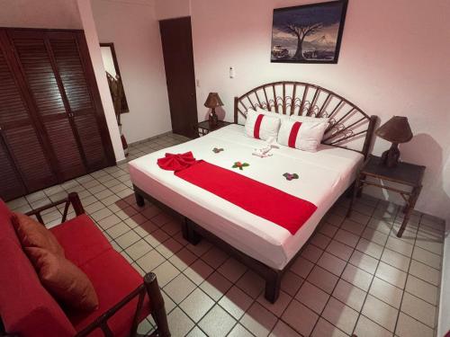 a bedroom with a bed with a red blanket at DEPARTAMENTOS LALO in Zihuatanejo