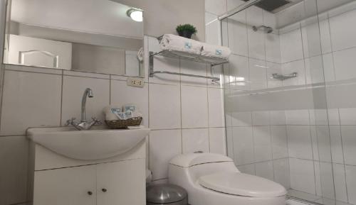 a white bathroom with a toilet and a sink at HOTEL MURCIA AREQUIPA in Arequipa