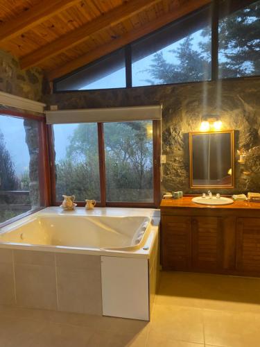 a large bath tub in a bathroom with a window at Huellas de Berna in Villa Berna