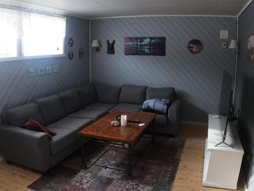 a living room with a couch and a coffee table at Komfortabel overnatting på veien mot Nordkapp in Kolvik