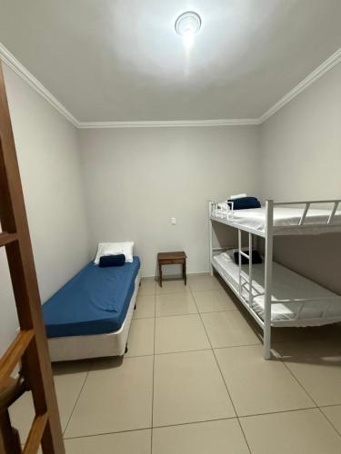 a room with two bunk beds and a lamp at Chácara 3 quartos com piscina e churrasqueira in Itatiba
