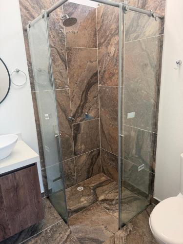 a shower with a glass door in a bathroom at Finca para estrenar in Anapoima