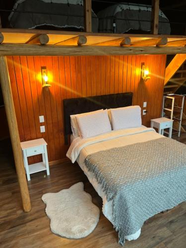 a bed in a room with two tables and two lamps at Domo ancud glamping in Lechagua