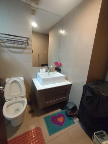 a bathroom with a toilet and a sink and a mirror at Monte Carlo Lounge Two in Manila