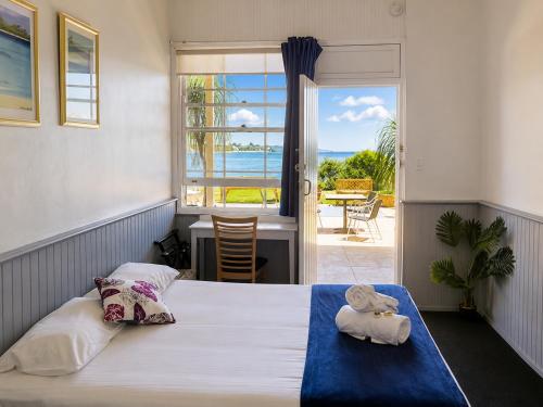 a bedroom with a bed with a view of the ocean at Squid's Ink Motel in Belmont