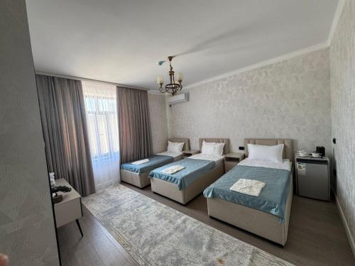 a bedroom with two beds and a chandelier at Zere Motel in Türkistan