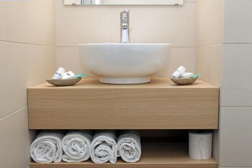 a bathroom with a sink and some towels at Hotel Méditerranée in Collioure