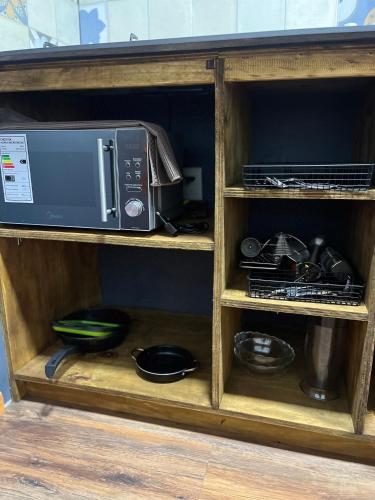 a microwave and other kitchen items on a shelf at Domo ancud glamping in Lechagua