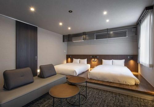 a hotel room with two beds and a couch at グランマリーナホテル in Osaka