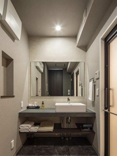 a bathroom with a sink and a large mirror at グランマリーナホテル in Osaka