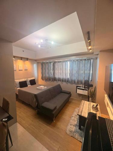 a bedroom with a bed and a couch and a window at Monte Carlo Lounge Two in Manila