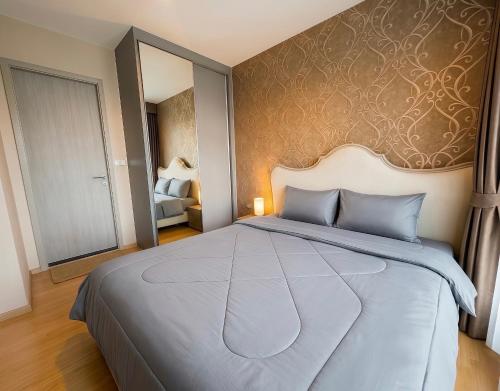 a bedroom with a large bed and a mirror at BTS Thong Lor Central High -rise Condo in Bangkok