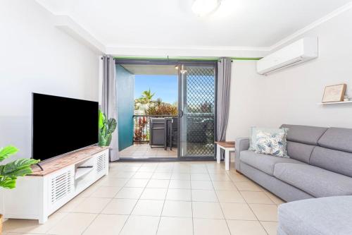 a living room with a couch and a flat screen tv at Sea Air 6 in Yeppoon