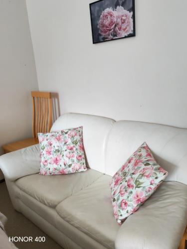 a white couch with two pillows on it at Light Home in Sodankylä