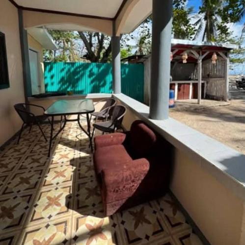 a couch sitting on a porch with a table and chairs at Hatch Guesthouse in Ocoy