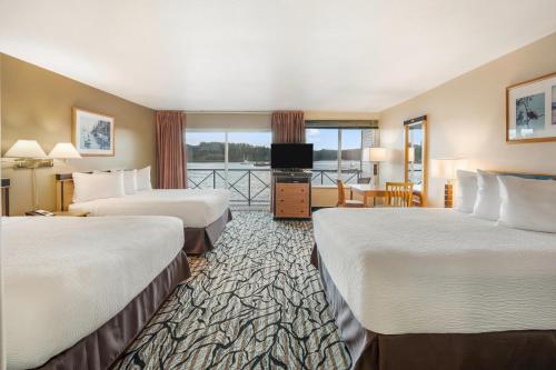 a hotel room with two beds and a balcony at Glen Lyon Inn in Port Hardy