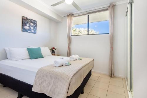a bedroom with a bed with two stuffed animals on it at Sea Air 24 in Yeppoon