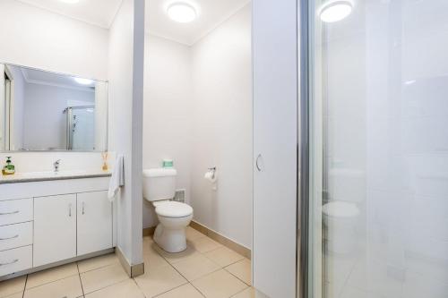 a white bathroom with a toilet and a shower at Sea Air 24 in Yeppoon