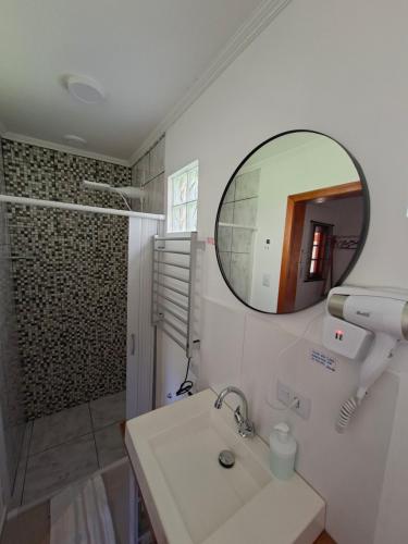 ein Badezimmer mit Waschbecken und Spiegel in der Unterkunft Chalé Cabana Ruby in Gonçalves