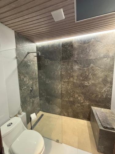 a bathroom with a toilet and a glass shower at DEPARTAMENTO DUPLEX 3 Habitaciones EN CUENCA ECUADOR in Cuenca