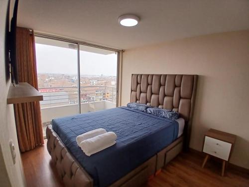 a bedroom with a large bed with a large window at Departamento VIP estreno en Condominio in Lima