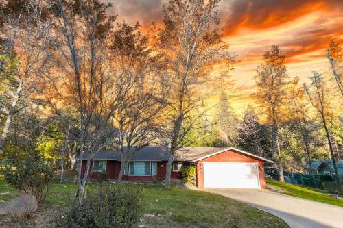 a house in the woods with a sunset at Mountain House in Mariposa