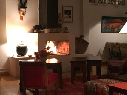 a living room with a fire in the fireplace at Auberge De La Plage in Sidi Kaouki