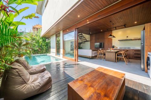 an open living room with a pool and a wooden table at Nala Villa - Peaceful Hideaway with Pool & Yoga Space in Canggu
