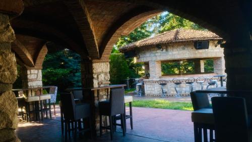 an archway with tables and chairs in front of a building at Hipodruma Resort & Pool in Dobrich