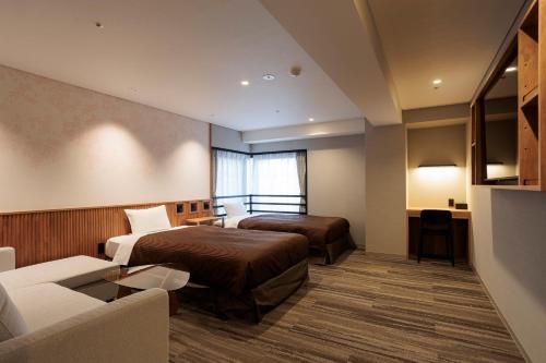 a hotel room with two beds and a couch at Tokyo Asakusabashi Belmont Hotel in Tokyo