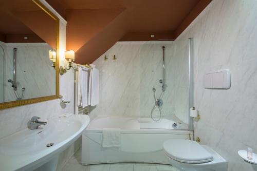 a bathroom with a tub and a toilet and a sink at Il Piccolo Castello in Monteriggioni