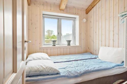 a bed in a room with a window at FY173-Asperup-Elmevaenget-8 in Asperup