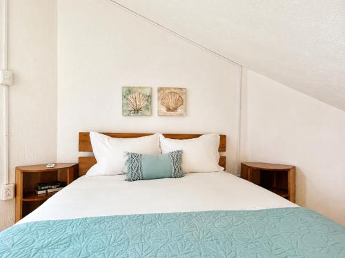 a bedroom with a bed and two paintings on the wall at Beachfront condo with loft and sea views in Puerto Aventuras