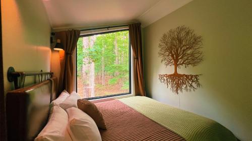 a bedroom with a bed with a tree on the window at Bison Farm - Cabin "Cielo" in Culpeper