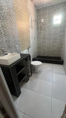 a bathroom with a sink and a toilet at Casa com piscina in Belfort Roxo