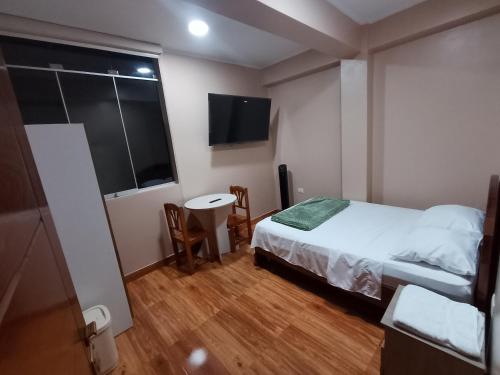 a bedroom with a bed and a table and a window at Casa Sol in Tingo María