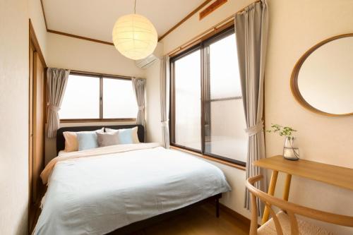 a bedroom with a bed and a large window at Matsumoto BASE in Matsumoto