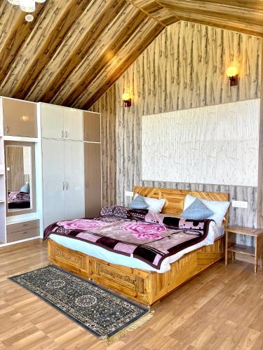 a bedroom with a large wooden bed in a room at Orchard Valley Resort in Mai Jūbar