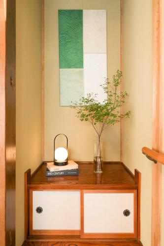 a table with a plant and a lamp on it at Matsumoto BASE in Matsumoto