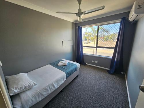 a bedroom with a bed and a large window at Rockhampton Court Apartment in Rockhampton