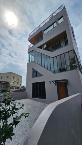 a large white building with glass windows at Shan Da Ke Qi Min Su in Zhonghe